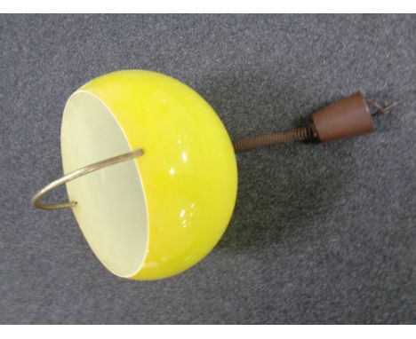 A 1970s pendant light fitting with yellow plastic shade  