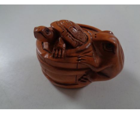 A carved Chinese hardwood netsuke, turtle and frog in a barrel 