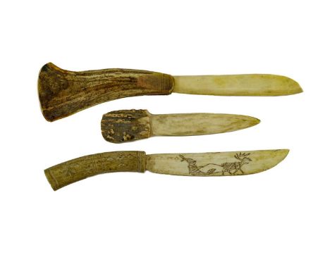 Three Inuit Knives, each with blade and grip carved from antler, one blade incised and stained with a caribou drawing a sled,