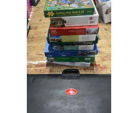 A job lot of assorted jigsaw puzzles and puzzle mat, shipping unavailable