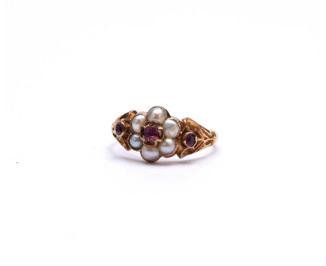 A late 19th/early 20th century pink sapphire and pearl floral cluster ring, with pink sapphire set scrolling pierced shoulder