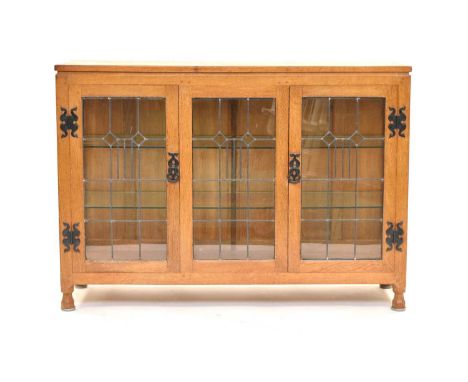 An Old Mill, Thirsk, light oak glazed display cabinet, the adzed top above leaded glass doors flanking a conforming centre pa