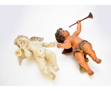 A collection of painted composition figures of putti, the winged cherubic figures in various poses playing violins and trumpe