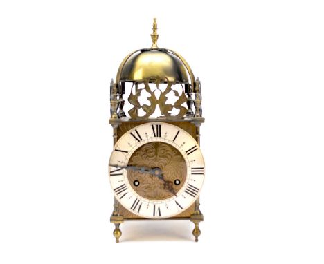 A late 19th/early 20th century lantern style clock by John Huntley of Barnsley, the strapped bell over turned finials, foliat