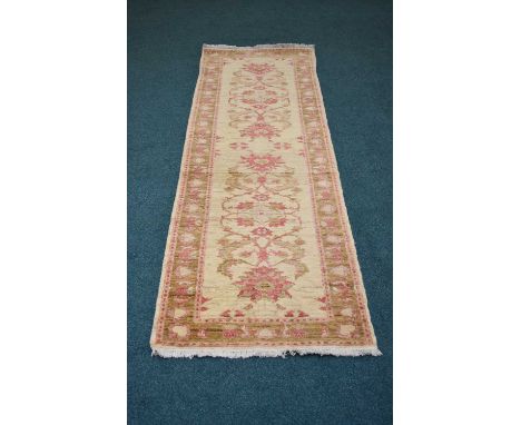 A Ziegler pattern runner, the central cream field with meandering flowers and foliage in dark pink and green, within a confor
