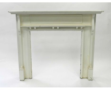 An Edwardian painted pine fire surround, with ogee and dentil mantel and shaped pilasters flanking an egg-and-dart border, 16