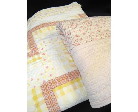 TWO VINTAGE PRINTED QUILTS, probably Welsh, pink floral 203 x 163cms (solied, holes), yellow pastel floral and plaid 274 x 24