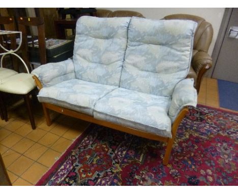 AN 'ERCOL' TWO SEATER SOFA, with pale blue floral upholstery