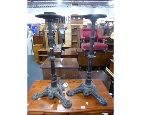 A PAIR OF BLACK PAINTED CAST IRON STANDS, with tripod bases
