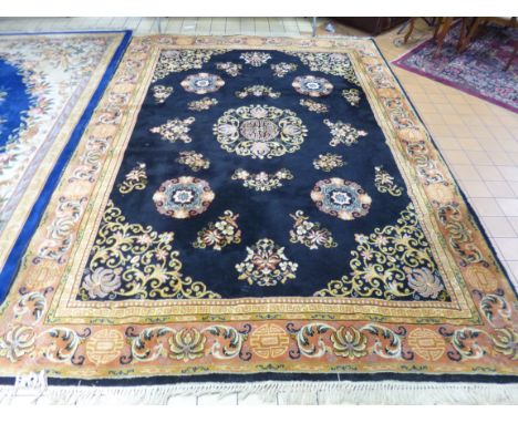 A BLACK GROUND CARPET, with terracotta boarder, approximate size 350cm x 250cm