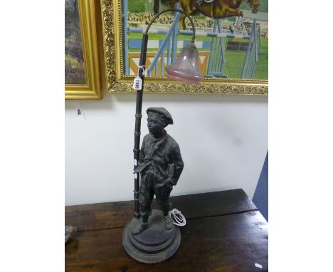 A BLACK PAINTED CAST SPELTER FIGURAL TABLE LAMP, 'Boy with hands in pockets under streetlamp', etched glass shade