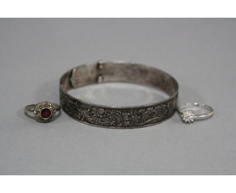 A FULLY ENGRAVED BANGLE, designed as a buckle, stamped WS Ltd Silver, a marcasite and garnet cluster ring, ring size O, stamp