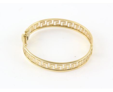 Greek key oval hinged bangle, with concealed clasp and two figure of eight safety catches, stamped 18 ct yellow goldCondition