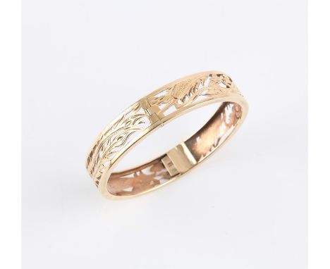 Chinese style gold hinged bangle, pierced work detail of a dragon and phoenix, concealed clasp stamped 14 ct yellow goldCondi