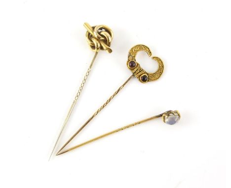 Three stick pins, including, cabochon moonstone pin, knot style pin and a Etruscan revival garnet set pin, with cannetille wo