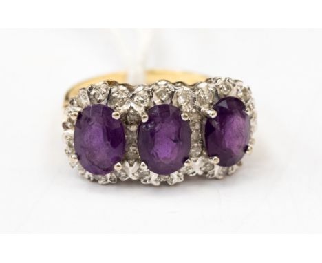 An 18ct gold ring set with three amethyst (damaged) surrounded by illusion set diamond chips, size S, with a total gross weig