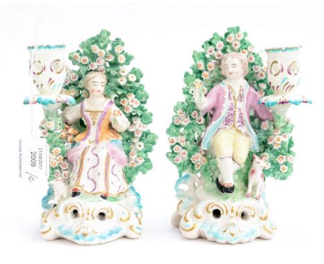 Pair of Derby Candlestick Figures  of a Boy & Girl. Seated on scroll bases, before bocage with a Lamb & Dog at their sides, d