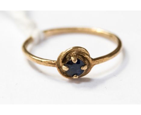 A 9ct gold and sapphire ring, with a knot style setting with a claw set sapphire set top the centre on a very fine band, size