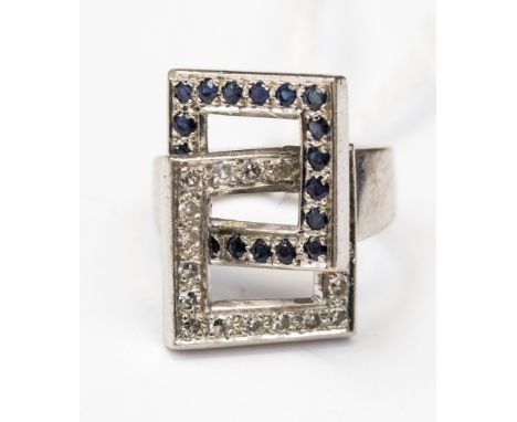 A white metal (possibl;y 18ct gold) diamond and sapphire ladies dress ring, with an interlocking square design, each side cla