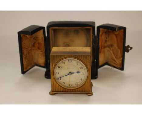 A Zenith circa 1920s cased travel alarm clock, having engine turned gilt metal decorated casing, dial having Arabic numerals 