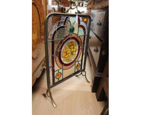 An early 20th Century stained glass leaded fire screen, with a brass frame