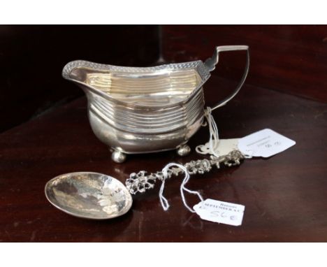 A George III silver milk jug with geometric border, raised on ball feet, London 1810; together with a Continental spoon with 