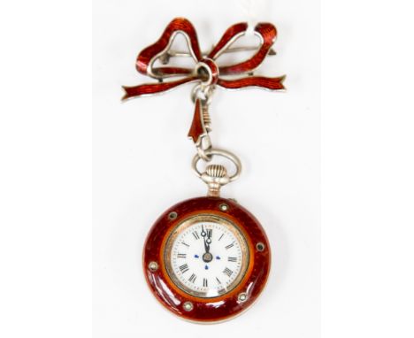 A white metal and red enamel ladies pocket watch with seed pearl bird to reverse, with an attached matching bow brooch, a/f p