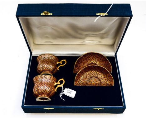 An Eastern set of two cups and saucers, hand painted, hand gilded and hand enamelled, complete with box, probably Indian, eac