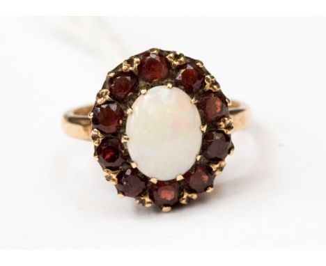 A 9ct gold, garnet and opal cluster ring, set with a central oval opal and garnet surround, size M, with a total gross weight