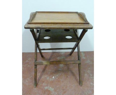 Oak butler's table with fitted tray top above a shelf with four apertures, on folding supports, 76cm high, 59cm wide and 59cm