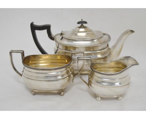 Silver three-piece tea service comprising a teapot, sugar and cream, with gadrooned border, hallmarks for Sheffield 1933-34, 