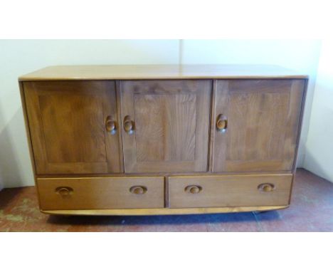 Mid-century Ercol 'Windsor' range elm sideboard with three cupboard doors enclosing a shelved interior, above two short drawe