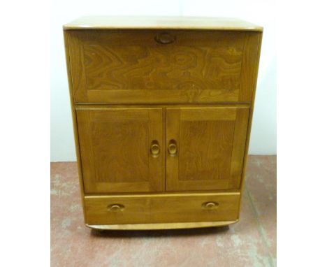 Mid-century Ercol elm cupboard with fall front above two cupboard doors enclosing a shelved interior, and a long drawer below