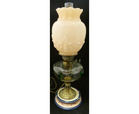 Art Nouveau oil lamp, probably British made, with glass reservoir decorated with stylised green glass iridescent motifs above