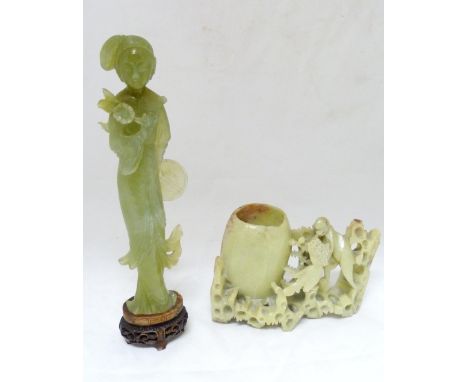 Chinese carved lime jade figure of a Geisha, probably Republic period, holding a lotus flower in her right hand and a fan in 