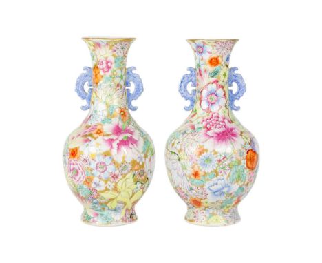 A pair of Chinese millefleur twin handled vases, circa 1900. Profusely decorated with enamelled flowers and foliage on a gold
