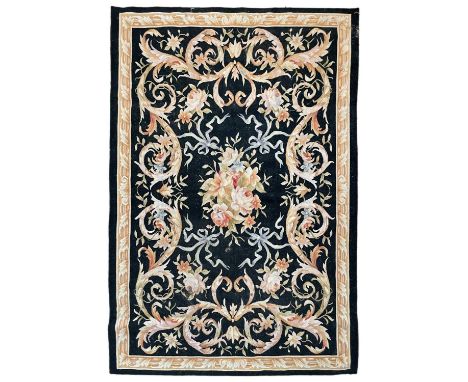 A European needlepoint tapestry / rug, mid 20th century. The charcoal field with a central polychrome floral medallion, 187 x