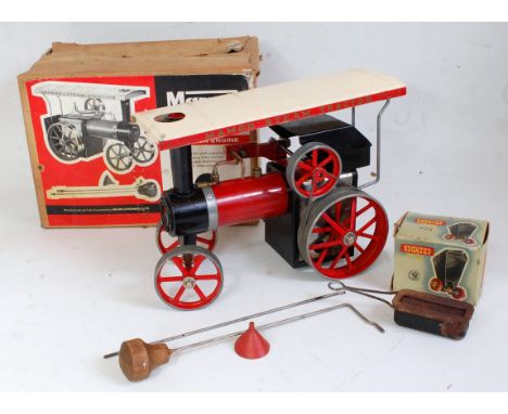 A Mamod TE1 traction engine finished in red with original canopy, steering rod, scuttle, and burner, sold in the original all