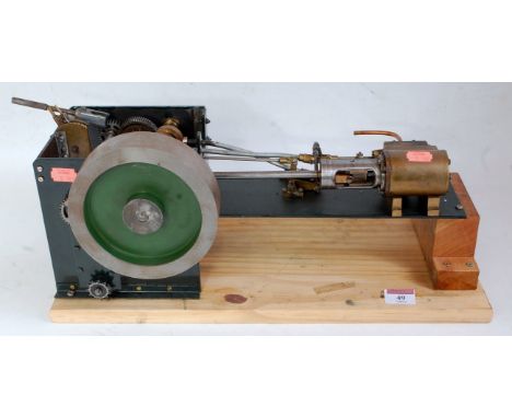 A home made scratch built horizontal steam engine comprising single cylinder with slip eccentric powering a large unspoked fl