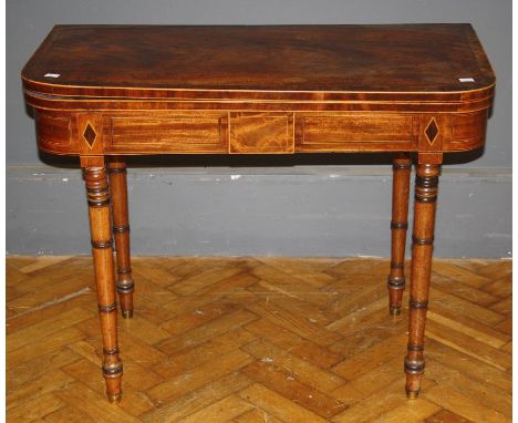 A George III mahogany, crossbanded and strung card table, the swivel folding top on ring turned tapering legs. 92cm wide