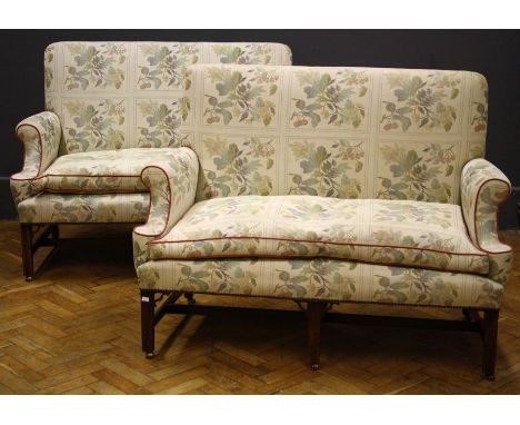 A pair of George III mahogany framed three seater settees upholstered in leaf pattern light coloured cream, the plain back ov