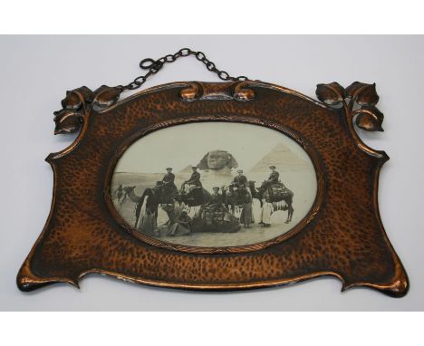 An early 20th century Arts and Crafts spot hammered copper photograph frame with scroll and leaf decoration. Inset with photo