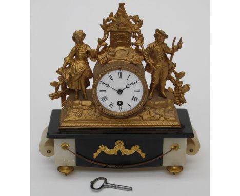A late 19th century French gilded spelter mantle clock, the figural drum case enclosing an eight day movement, faced by ename