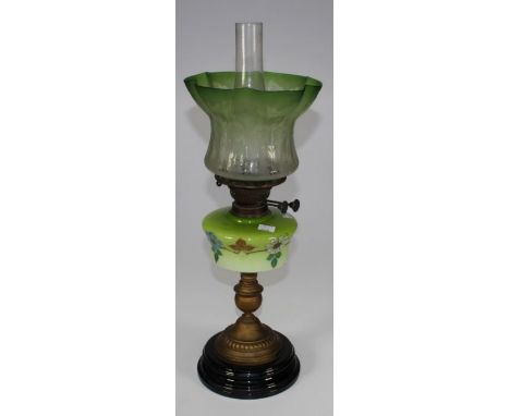 An Edwardian paraffin lamp, with florally etched green glass shade and painted reservoir on gilded column and stepped ceramic