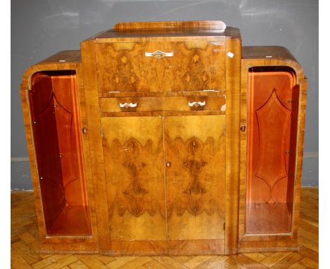 A 1930's Art Deco walnut cocktail cabinet, the rising top and fall front enclosing mirrored interior over drawer and cupboard