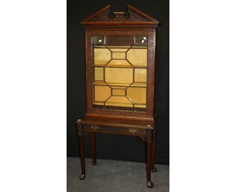 An Edwardian mahogany 'Chinese Chippendale' bookcase on stand, the broken architectural pediment over an astragal glazed door