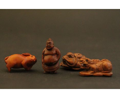 Four wooden miniature netsuke figures to include a Chinese Dragon, Rabbit, Buddha and one other