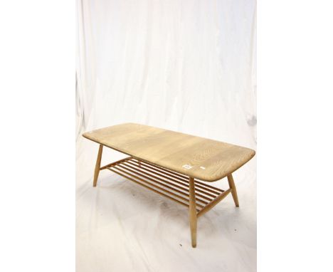Ercol Pale Elm Top Coffee Table raised on a beech turned legs and slatted book shelf