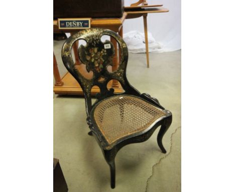 19th century Black Lacquered Nursing Chair decorated with floral sprays and mother of pearl with cane seat and raised on cabr