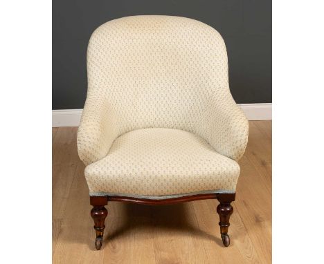 A Victorian upholstered low chair the turned front legs terminating in brass and ceramic casters, 65cm wide x 63cm deep x 34c